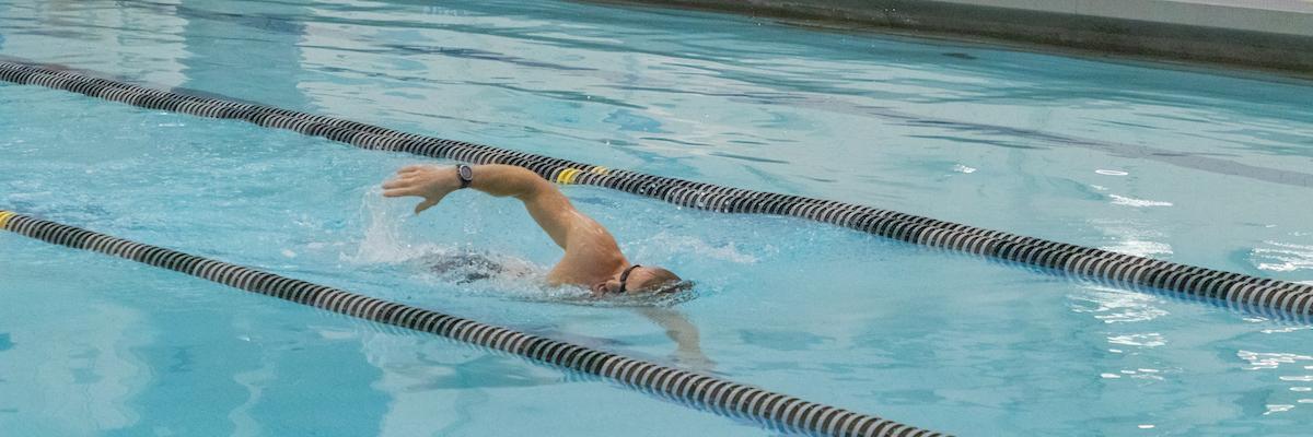 male patron swimming laps in pool