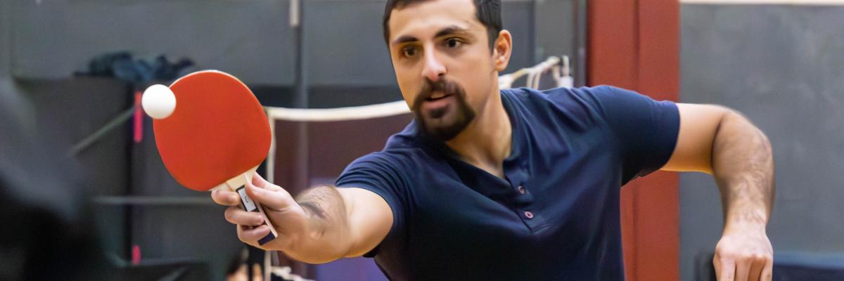 Student playing table tennis during Intramural Sports tournament