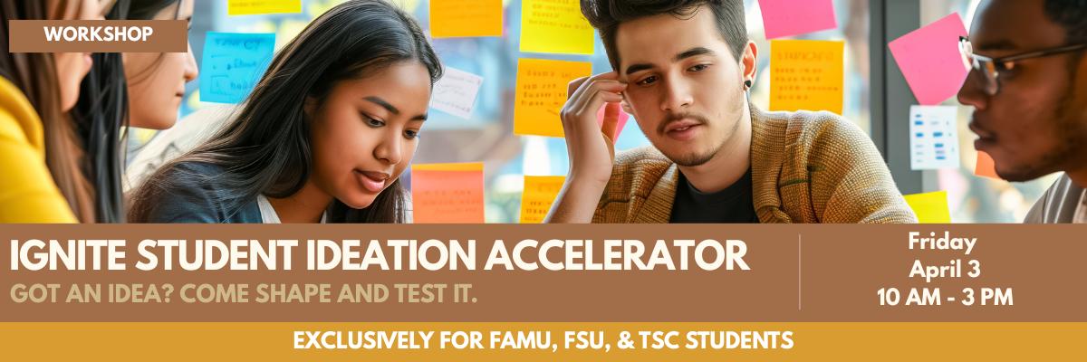 Students sitting at a table with post-it notes behind them, on a wall.