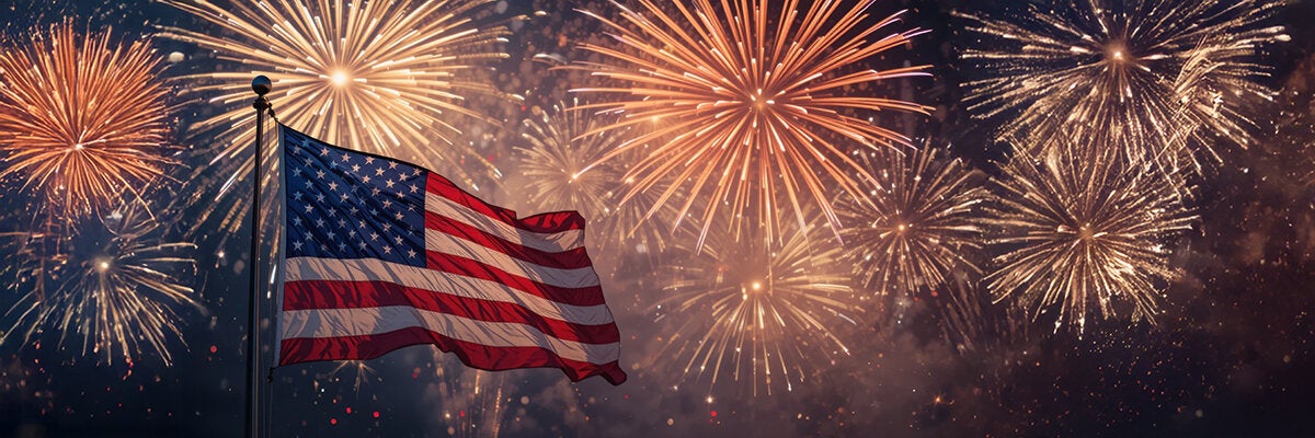 American flag with fireworks in the background.