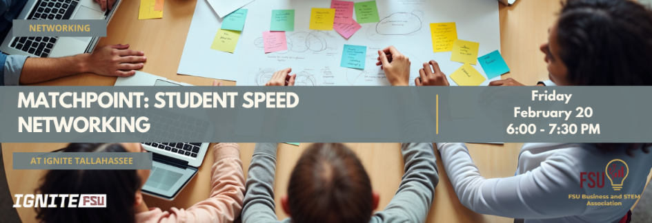 Students sitting at a table reviewing notes and using laptop computers.