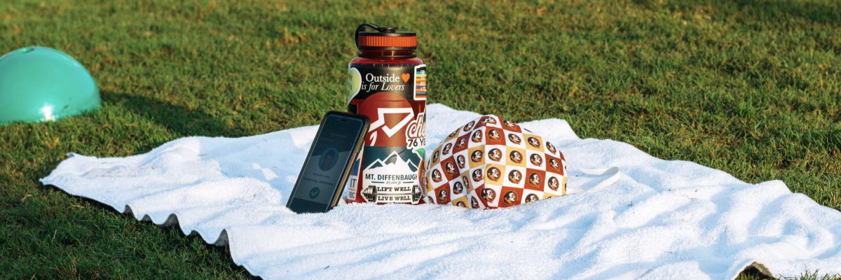 Water bottle, mask and iPhone on a towel