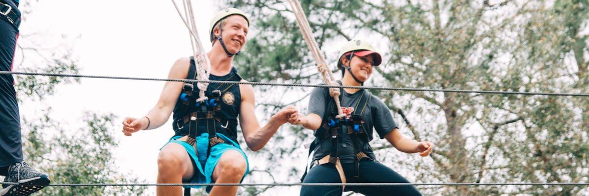 Male and female pair on high ropes course