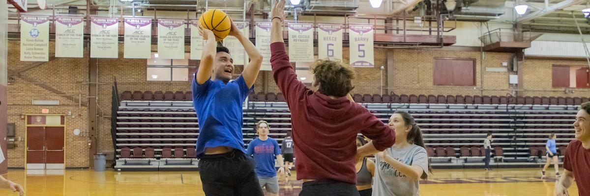 male students playing basketball