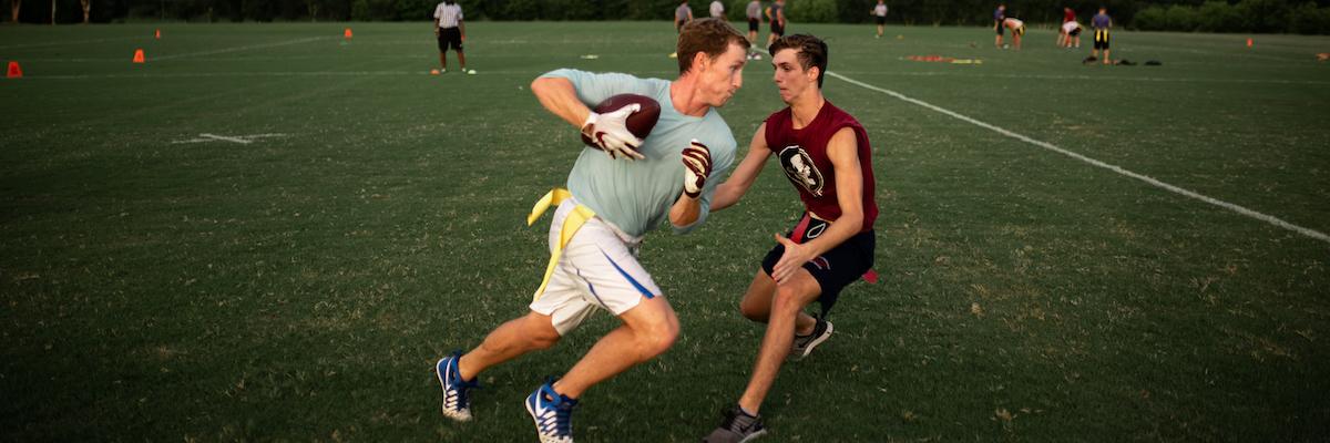 Two male students playing flag football