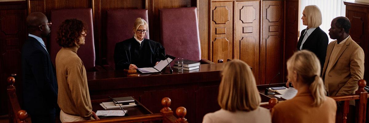 A judge in a courtroom surrounded by people.